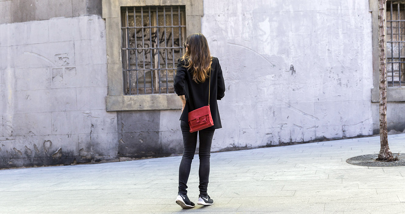 look de street style con blazer negra, camisa de cuadros, jeans reiko, zapatillas nike y bolso rojo bandolera de hakei