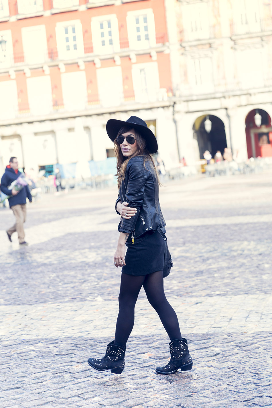 Look de street style con minifalda negra, cazadora de cuero estilo motera de Zara, sombrero fedora, bolso de cuero estilo saco y botines de tachuelas de Hakei. Bárbara Crespo