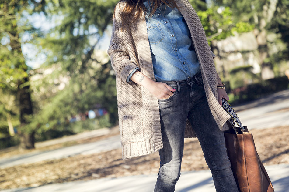 look de street style con cardigan de lana en color beige, camisa vaquera , jeans pitillo, botines y volos de cuero marrón estilo shopping