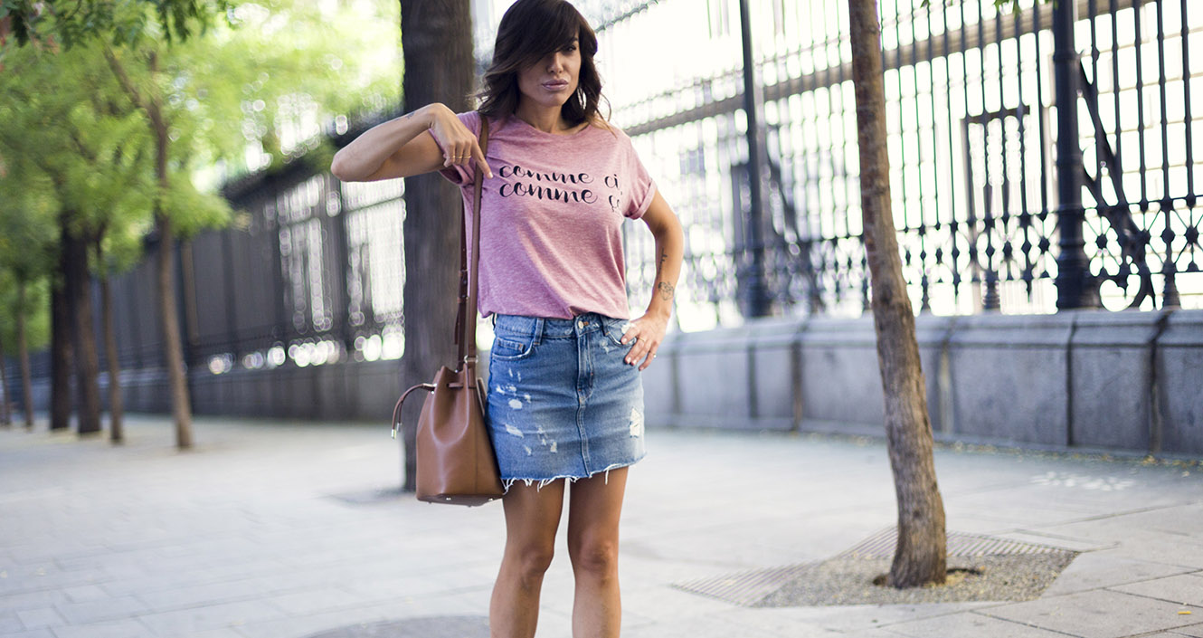 street style con camiseta con mensaje de a bicyclette, mini vaquera con desgastados de Zara y sandalias planas con animal print