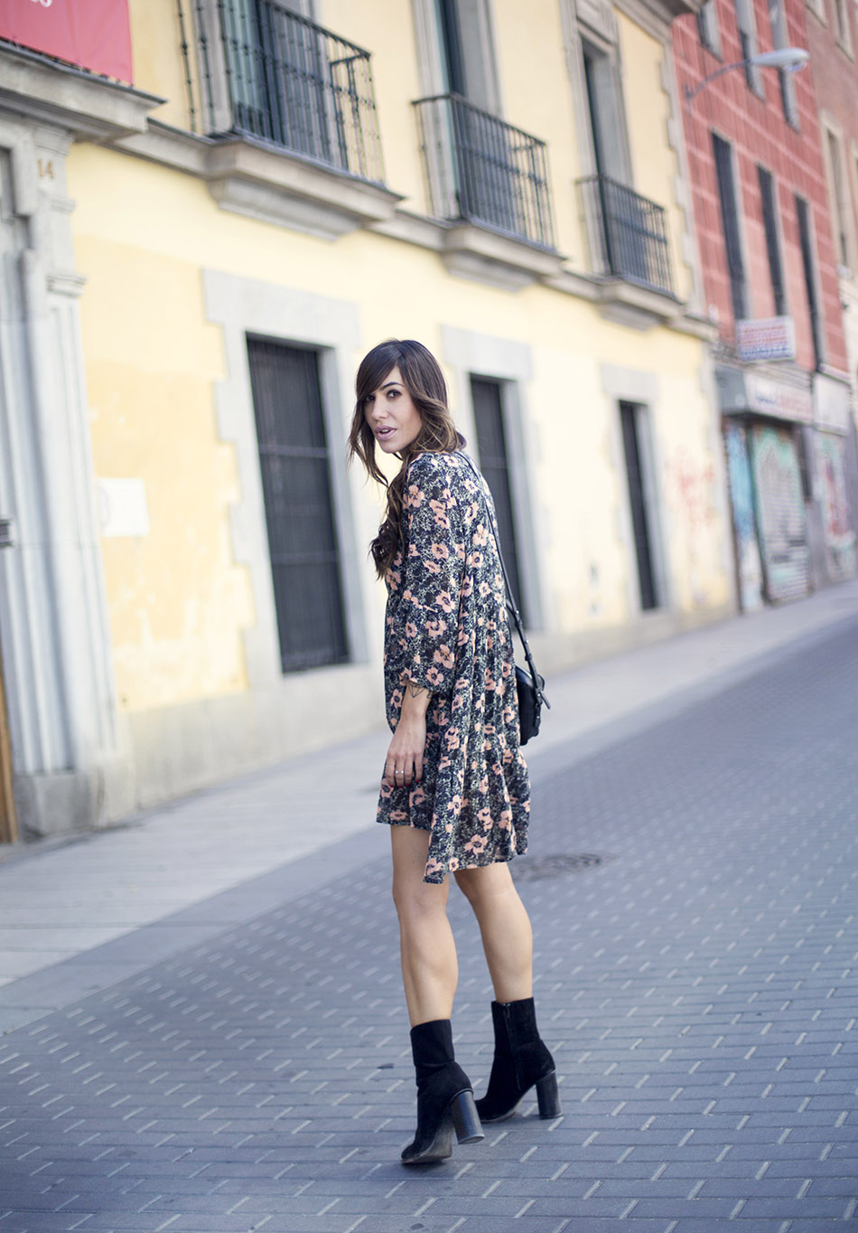 look de street style con vestido tipo túnica con estampado floral de American Vintage, botines de ante de mango y bolso pequeño de cuero negro