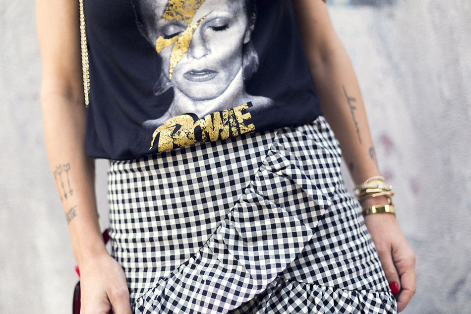look de street style con camiseta de David Bowie, falda de cuadros vichy, botines de Chloe y bolsito rojo
