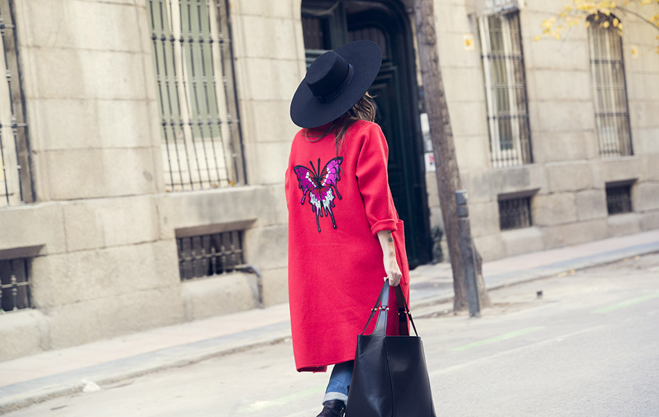 look de street style con abrigo rojo, camiseta con animal print, jeans desgastados de zara, reloj digital michael kors, gafas de sol redondas