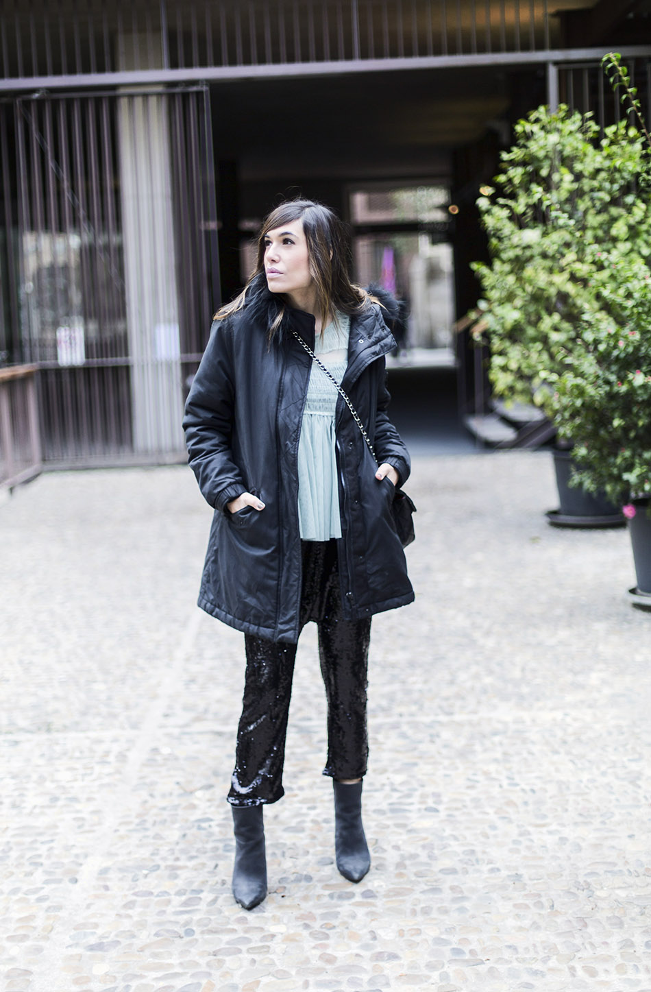 look de street style con parka negra, blusa de tul verde menta de Zara, pantalones de lentejuelas de Zara y bolso de Chanel