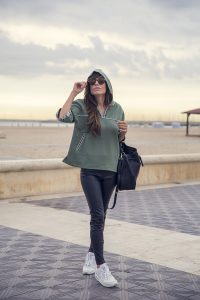 look de street style con sudadera con capucha en color verde militar de hakei, jeans negros, nike airmax blancas y bolso estilo saco bandolera de Zara