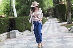 look de street style con sombrero de color beige, camiseta con mensaje, jeans de mango con volantes en los laterales, zapatos Chanel